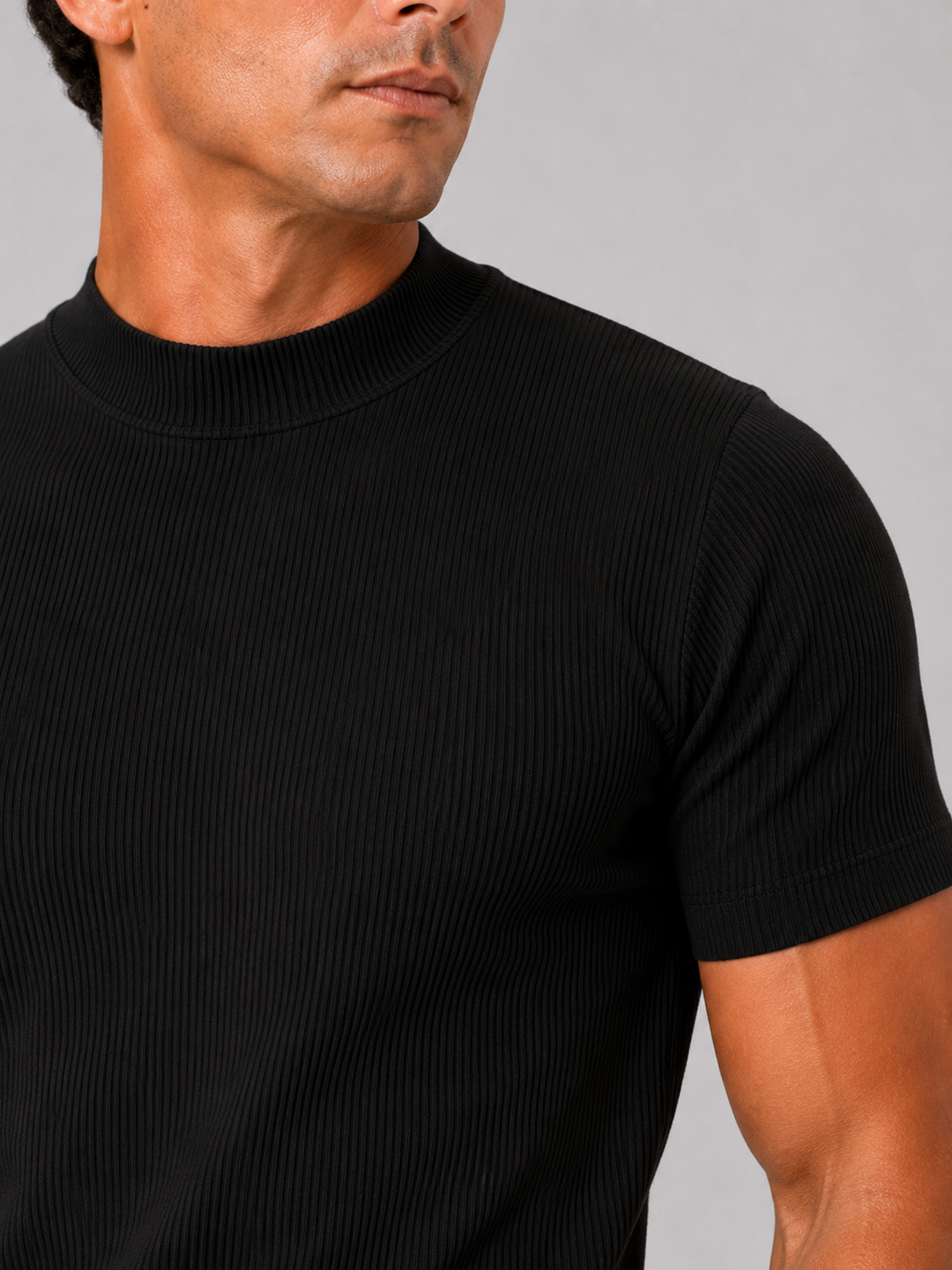 Close-up of the black ribbed fabric, mock neck collar and short sleeve hem on a men's tee.