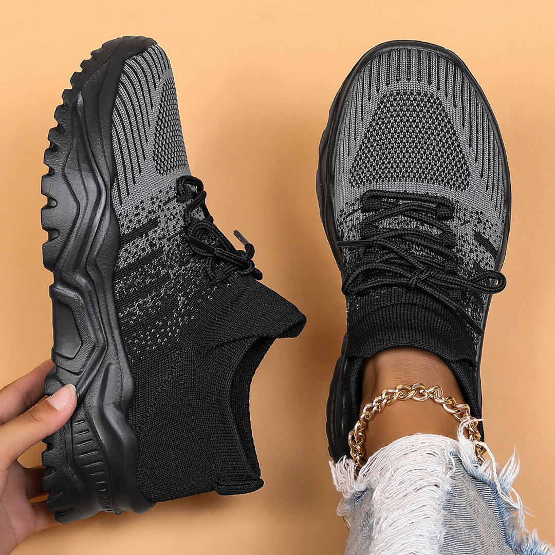Black and gray knit sock-style sneakers with chunky treaded soles, top-down view.