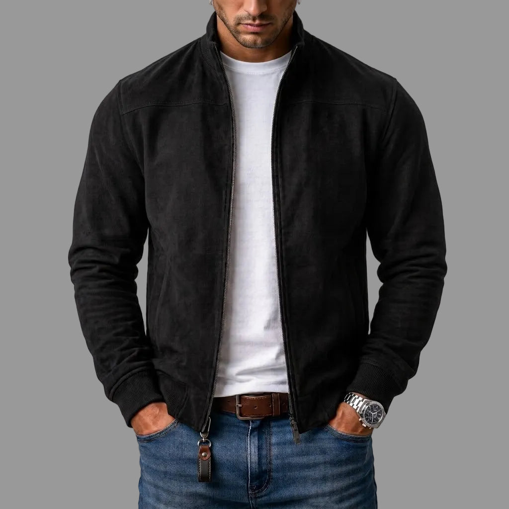 Black suede-look bomber jacket with ribbed cuffs and brown leather zipper pull, worn open over a white tee and jeans.