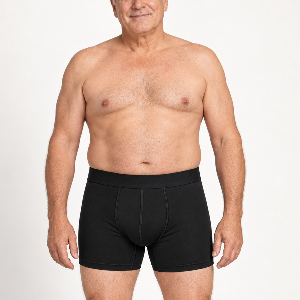 Smiling older shirtless man wearing black boxer briefs with a wide waistband, shown from the front against a white background. 2