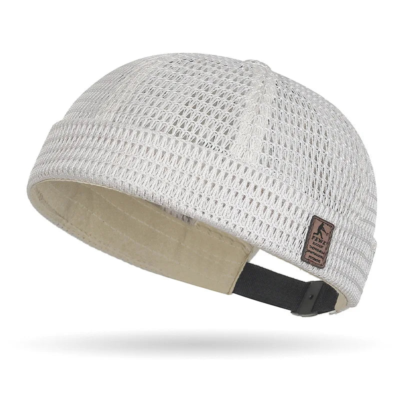 Cream white open weave brimless cap seen from the side, with beige lining and a black strap 16