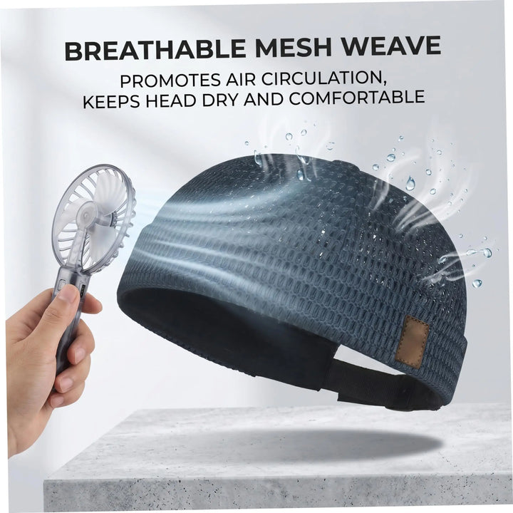 Dark blue open weave cap beside a handheld fan, showing air flowing through the mesh 3