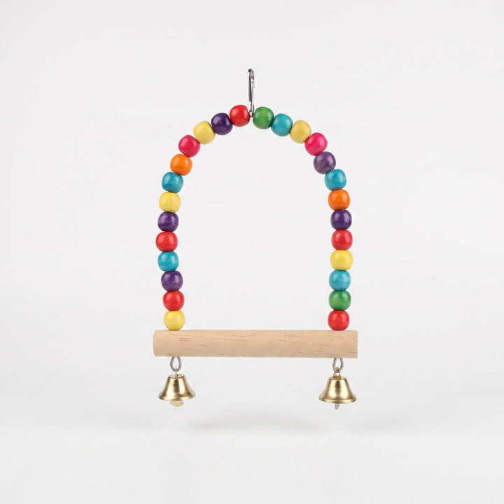 Front view of an arched swing strung with multicolored wooden beads, a natural wood perch bar, two small gold bells and a metal hook. 1