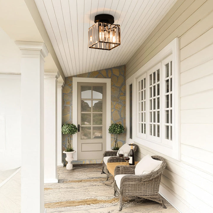 Black square ceiling light in a porch ceiling above wicker chairs.