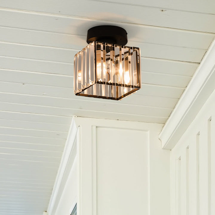 Black square ceiling light viewed from below at an angle on a white wood-plank ceiling.