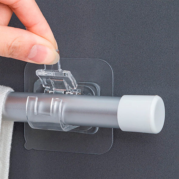 Clear clip-on storage hook detail holding a frosted rod against a dark wall.