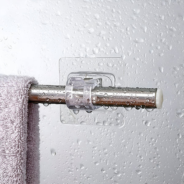 Clear clip-on storage hook holding a steel rod with a lavender towel on a shower wall.
