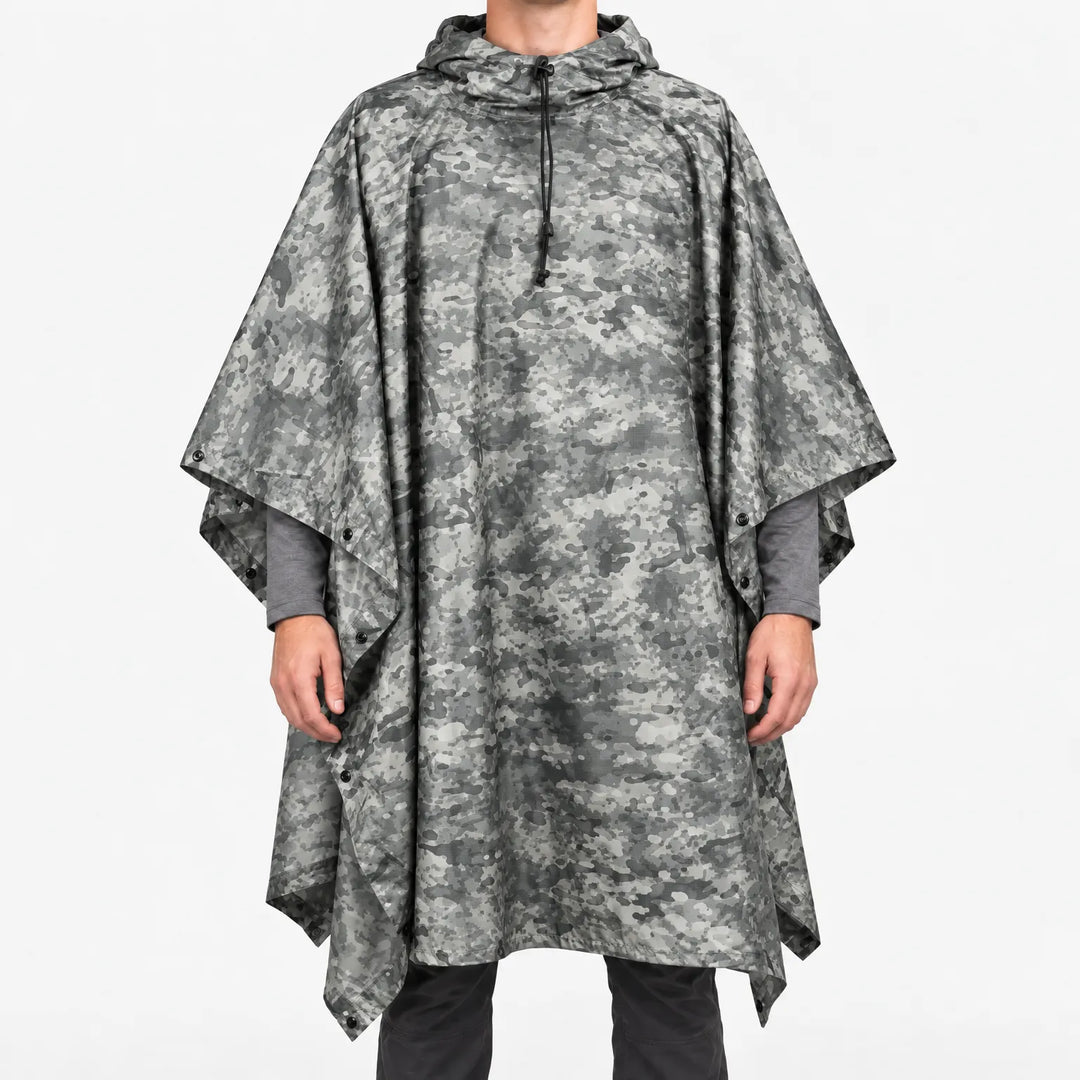 Front view of a hooded poncho in gray digital-style camouflage with small speckled patterns, worn over a gray long-sleeve shirt. 12