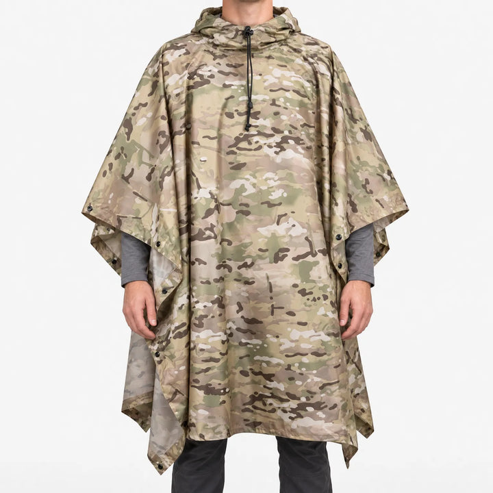 Front view of a hooded poncho in tan, green and brown camouflage worn over a gray long-sleeve shirt, with drawcord and snaps. 2