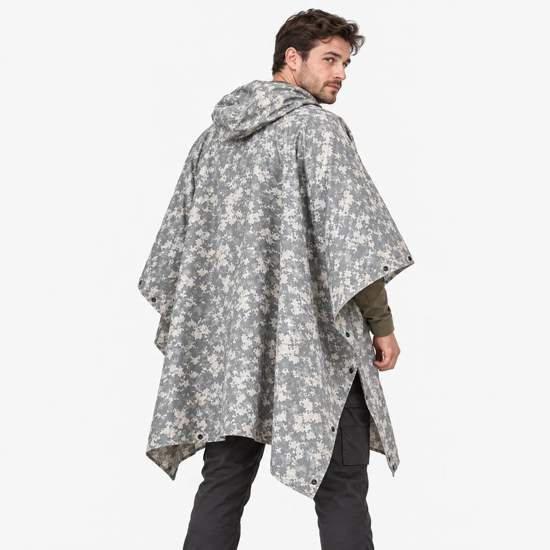 Back view of a man looking over his shoulder in a hooded poncho with gray and cream pixelated camouflage and side snaps. 4