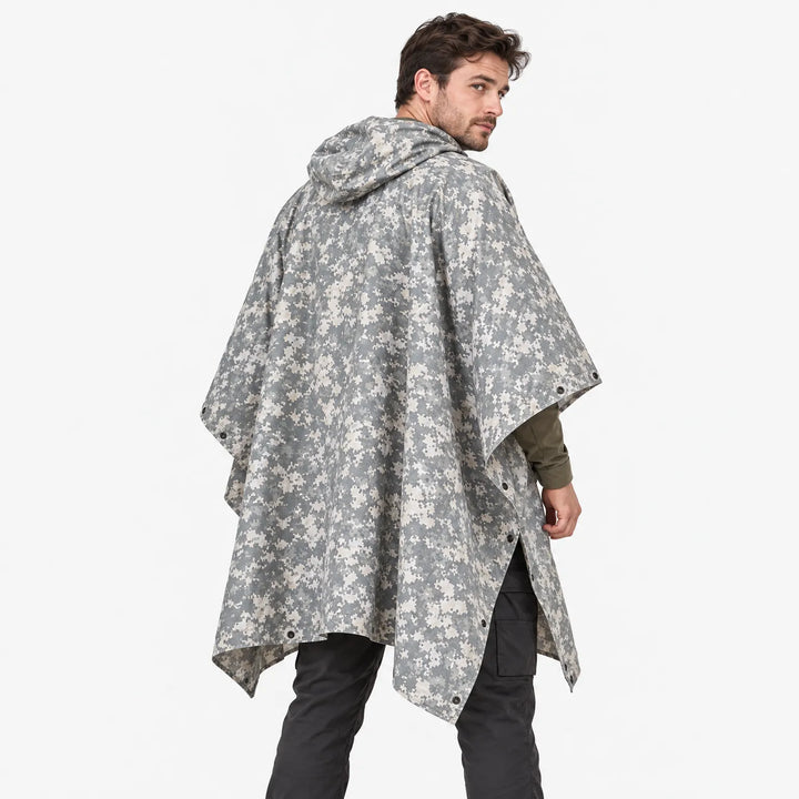 Back view of a man looking over his shoulder in a hooded poncho with gray and cream pixelated camouflage and side snaps. 4