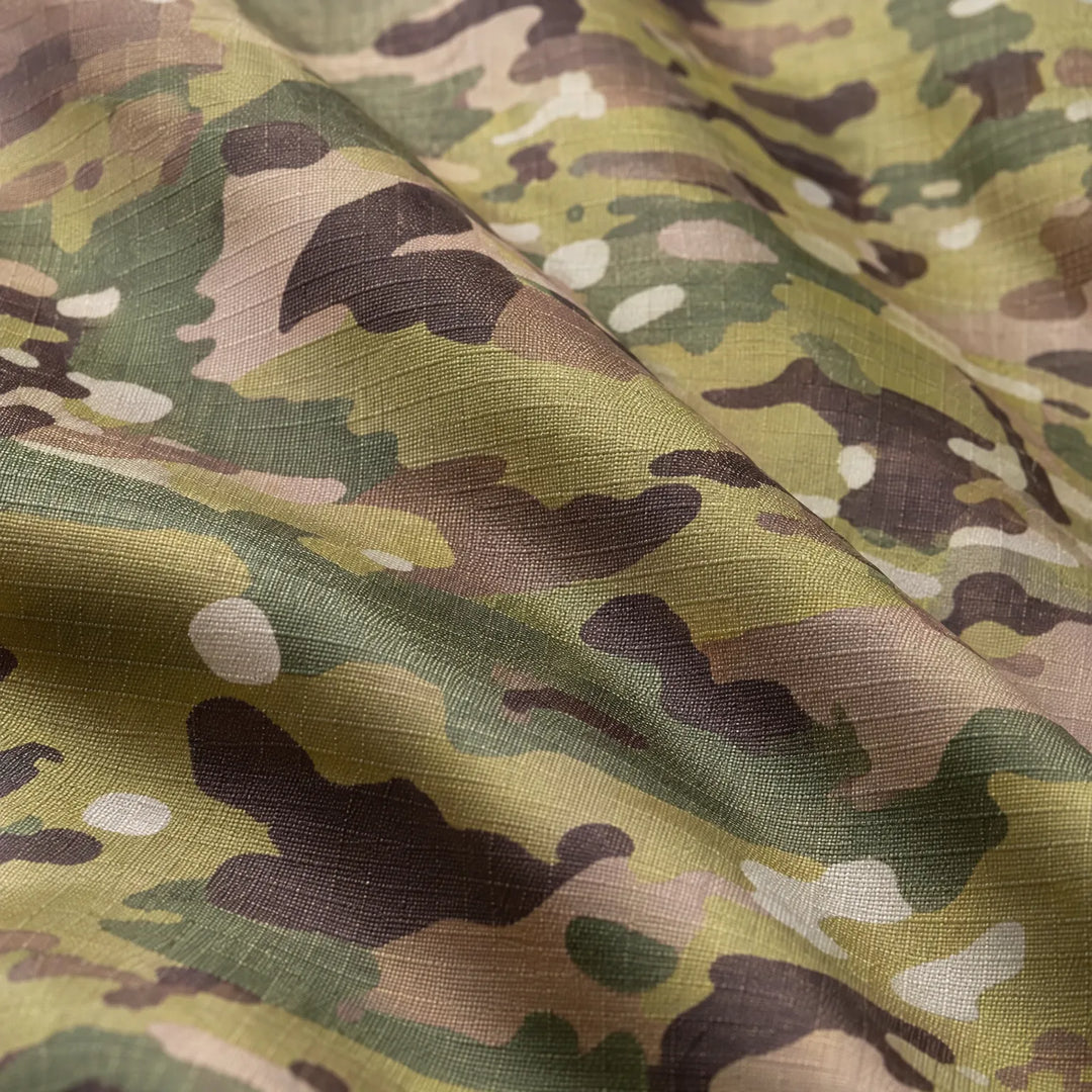 Close-up of folded ripstop fabric printed with green, brown and tan camouflage, showing the fine woven grid texture. 6