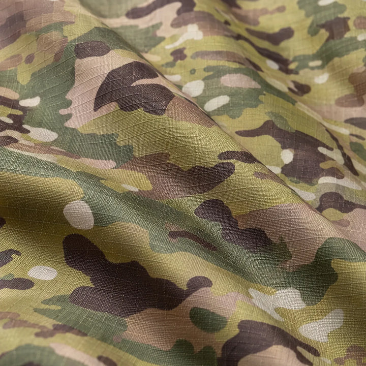 Close-up of folded ripstop fabric printed with green, brown and tan camouflage, showing the fine woven grid texture. 6