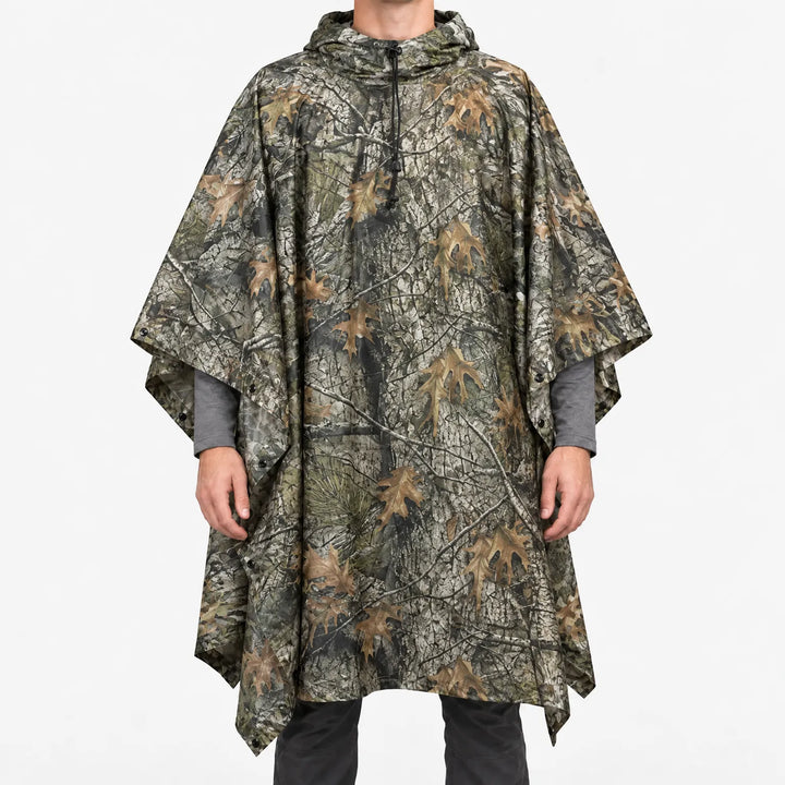Front view of a hooded poncho printed with realistic tree bark, branch and oak leaf camouflage in brown and gray tones. 9