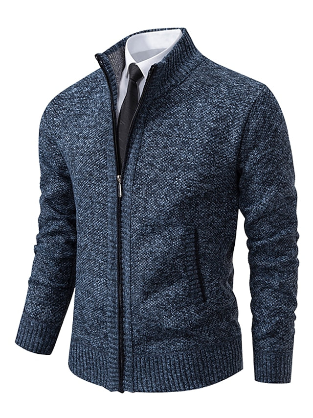 Blue mottled knit zip-up cardigan with stand collar and ribbed hem, shown over a white shirt and dark tie.