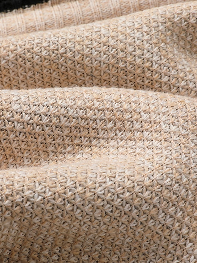 Detail of the beige textured knit fabric with the star-shaped stitch pattern in soft folds.