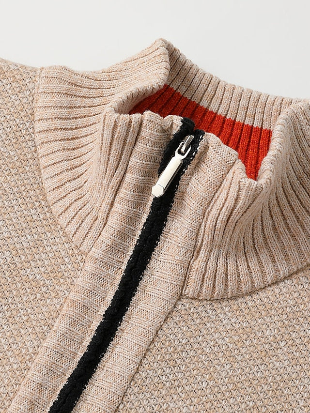 Detail of the beige stand collar and zipper with black trim, revealing an orange ribbed inner collar.