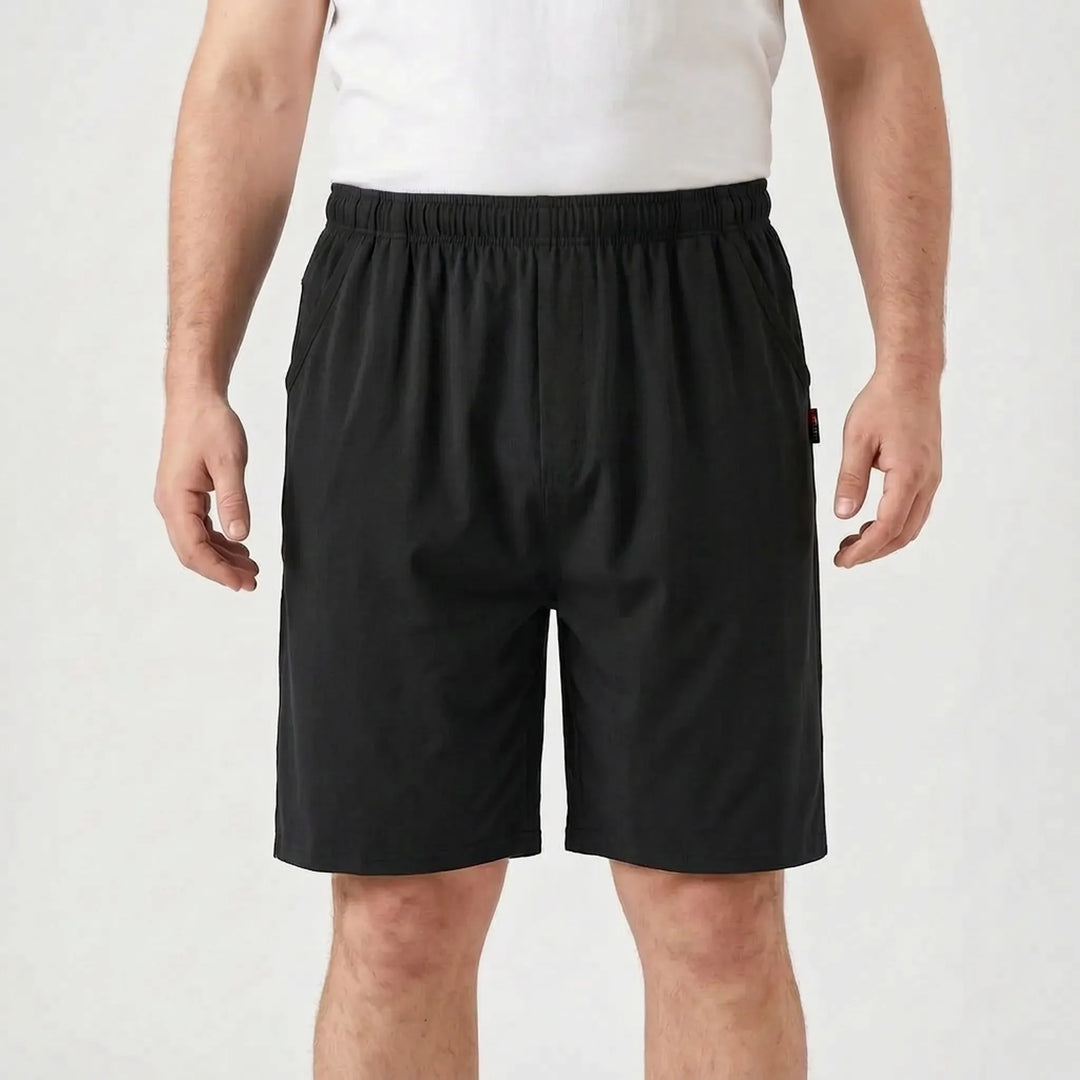 Front view of the shorts in solid black on a model in a white tee, showing the elastic waistband and side pockets. 7