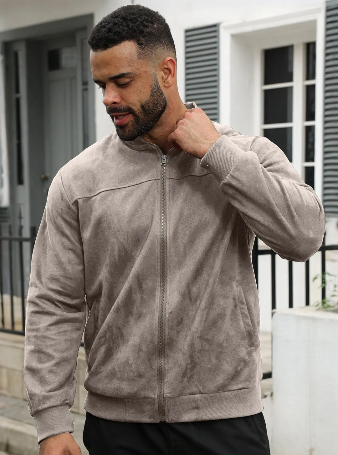 Man wearing the taupe zip-up jacket outdoors, hand at his collar, front view 26