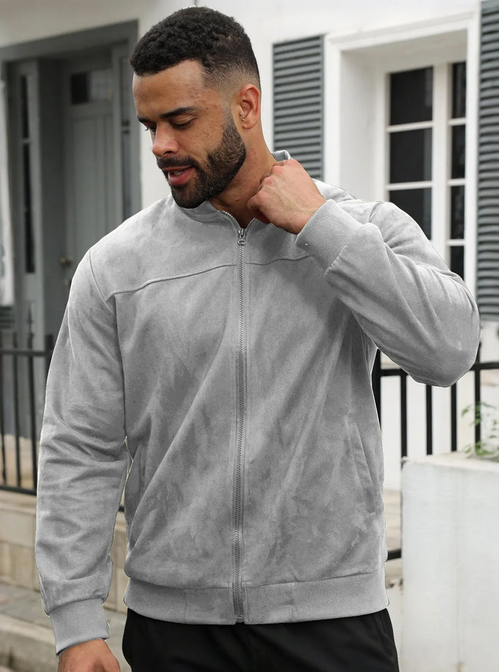Man wearing the light gray zip-up jacket outdoors, front view with hand raised to his collar 33