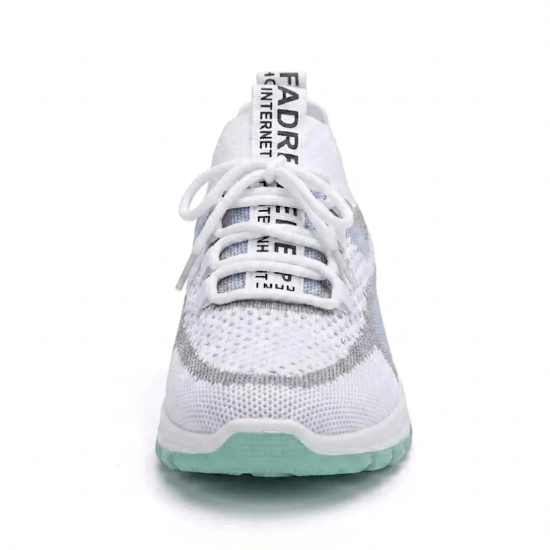 Front view of the white sneaker with a mint green outsole, a rounded toe box, white laces and a pull tab at the tongue.