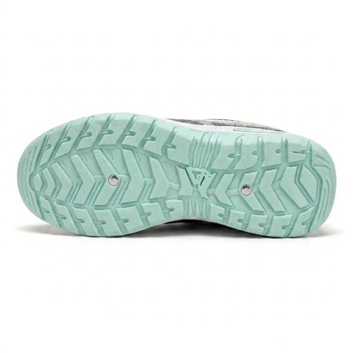 Bottom view of the mint green outsole showing a deep chevron tread pattern with two small metal studs. 18