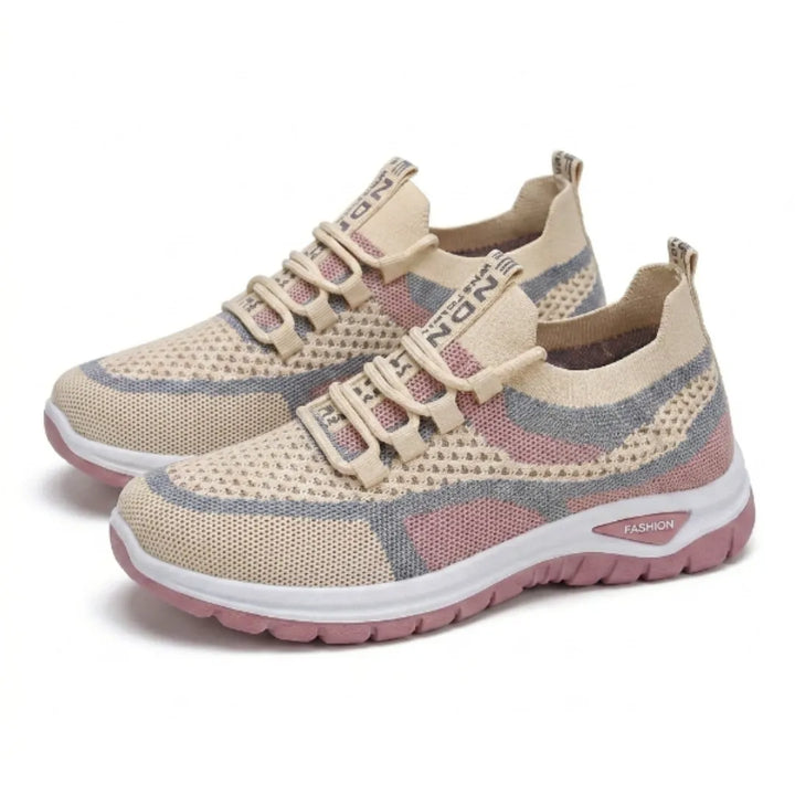 Pair of beige knit mesh sneakers with pink and gray panels, elastic laces, and white midsoles with pink outsoles, shown at a three-quarter angle. 34