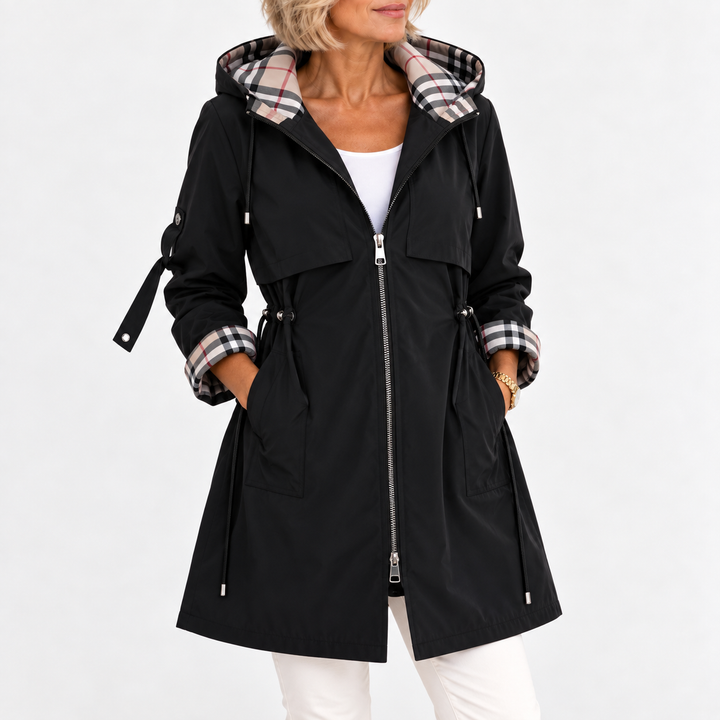 Black hooded coat worn zipped open over a white top, with plaid hood lining, cuffs and drawstring waist 4