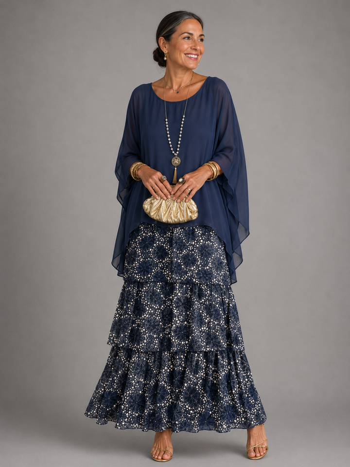 Maxi dress with a navy cape top over a tiered skirt in a navy and cream dotted print