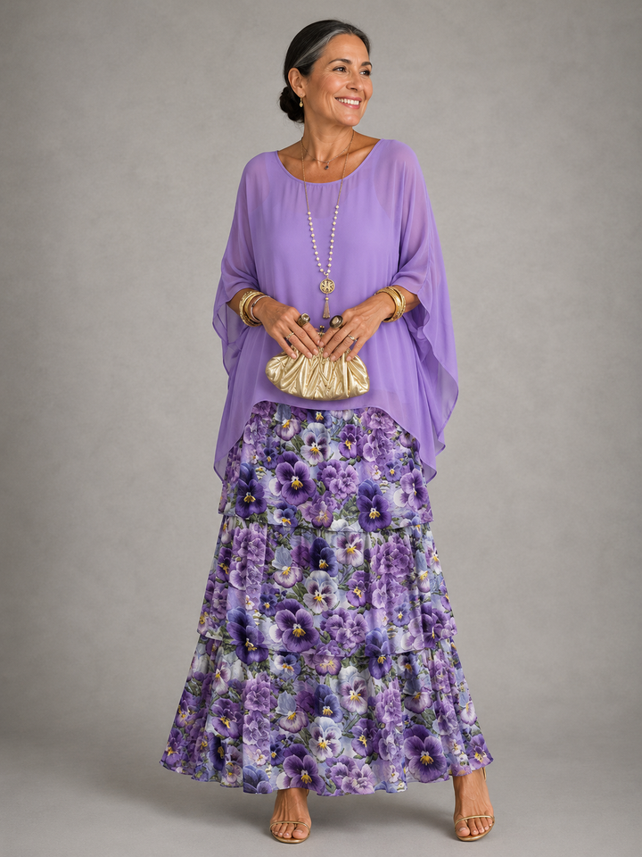 Maxi dress with a lavender cape top over a tiered skirt printed with purple pansies