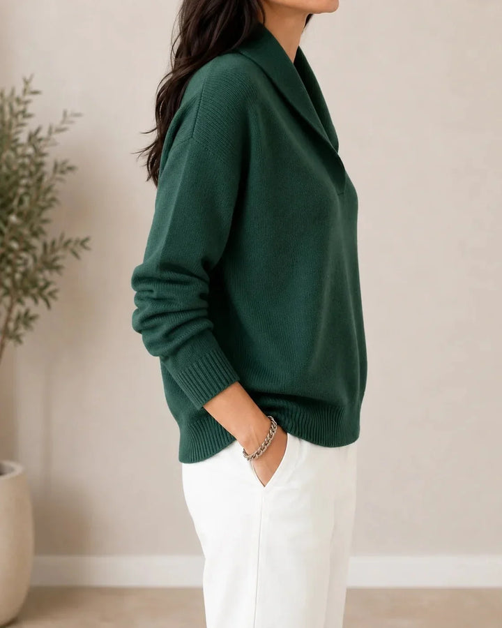 Side view of the dark green sweater on a model, showing the shawl collar, sleeve and ribbed hem. 3
