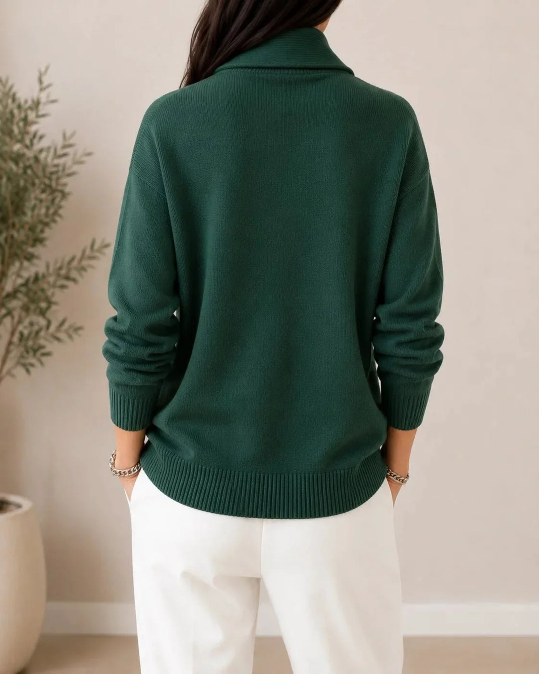 Back view of the dark green sweater worn by a model, showing the plain back, ribbed cuffs and hem. 4