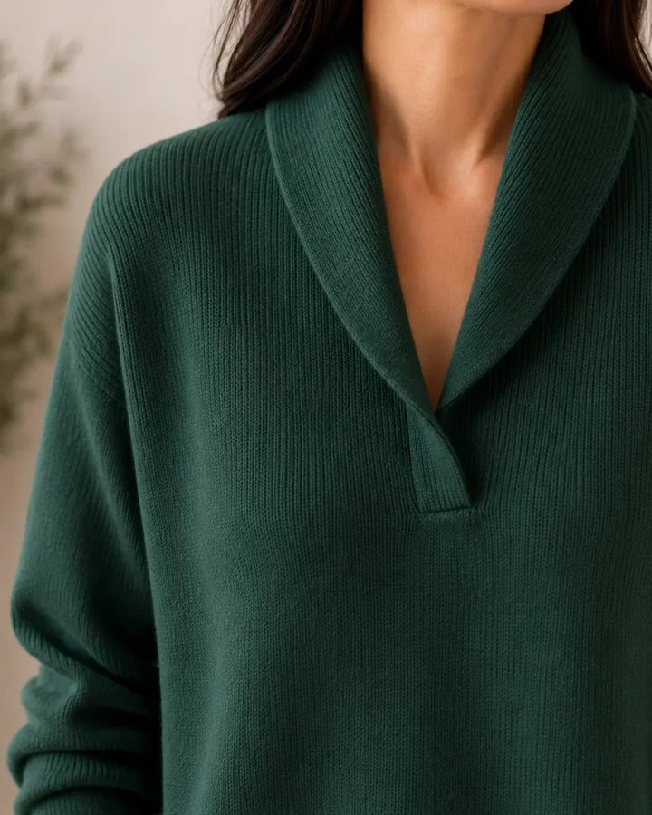 Close-up of the dark green sweater's shawl collar and V opening, showing the fine ribbed knit texture. 5