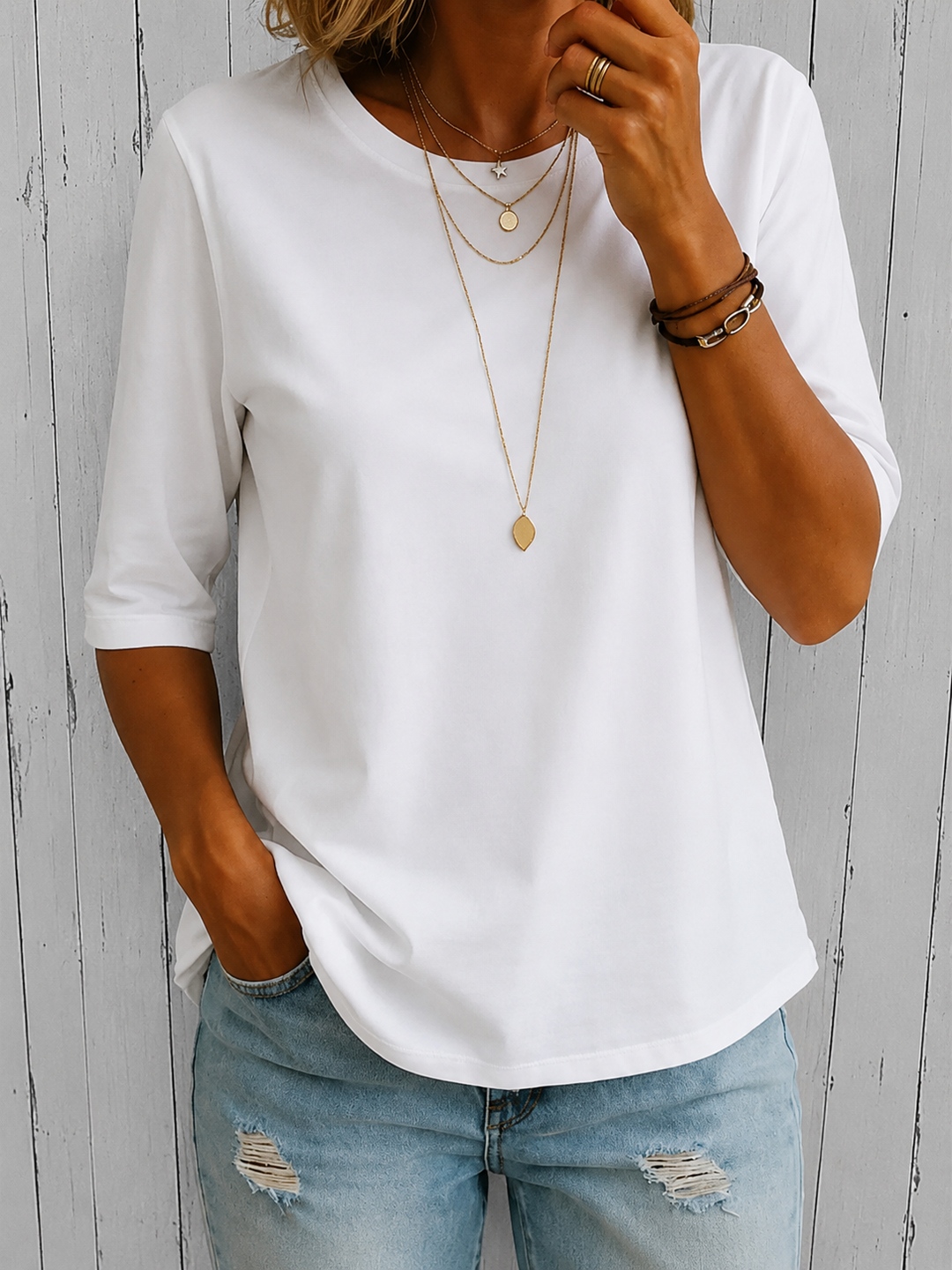 White half-sleeve tee with a crewneck and layered gold necklaces, another view.
