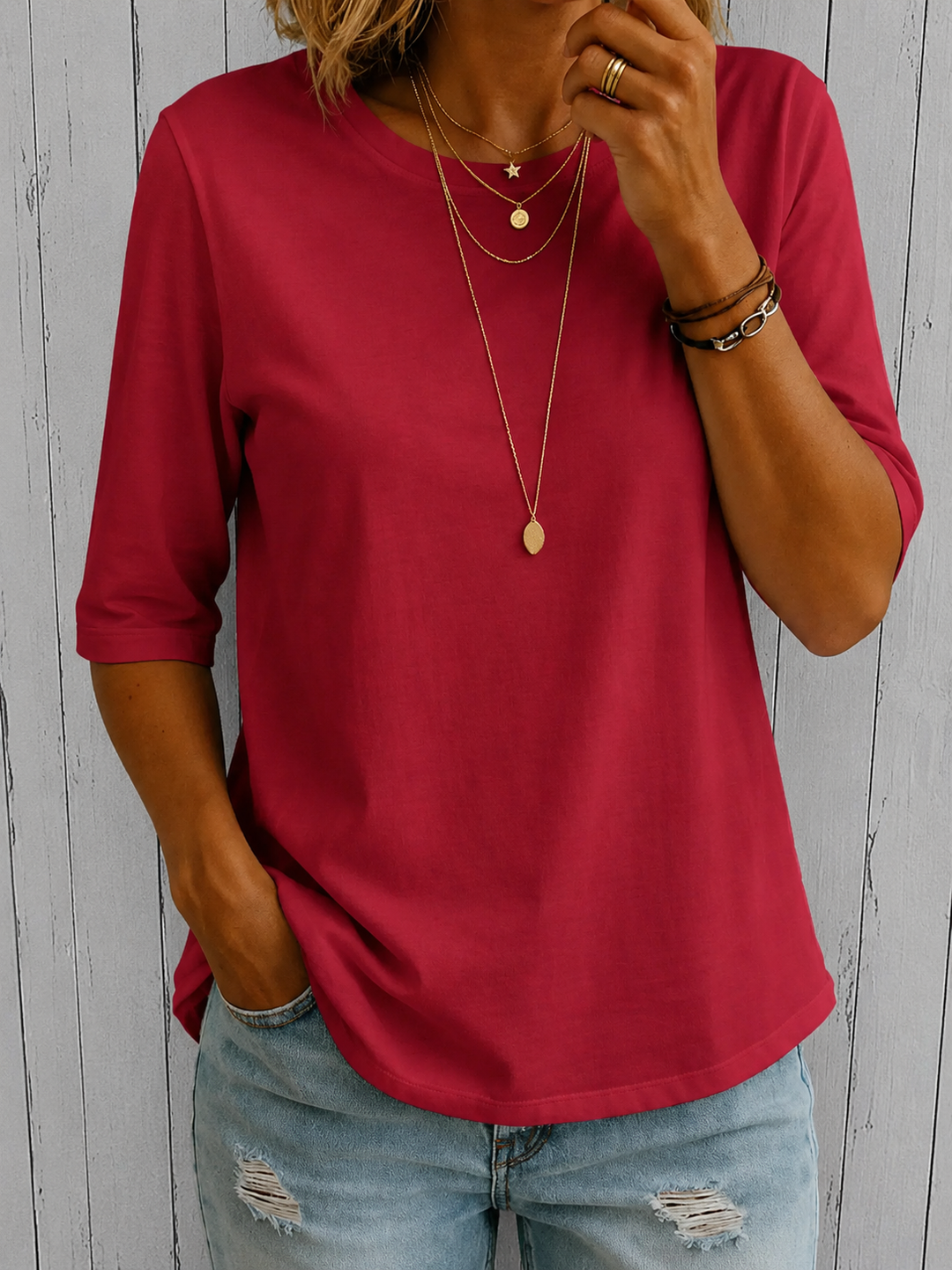 Deep red half-sleeve tee with a crewneck and layered gold necklaces, another view.