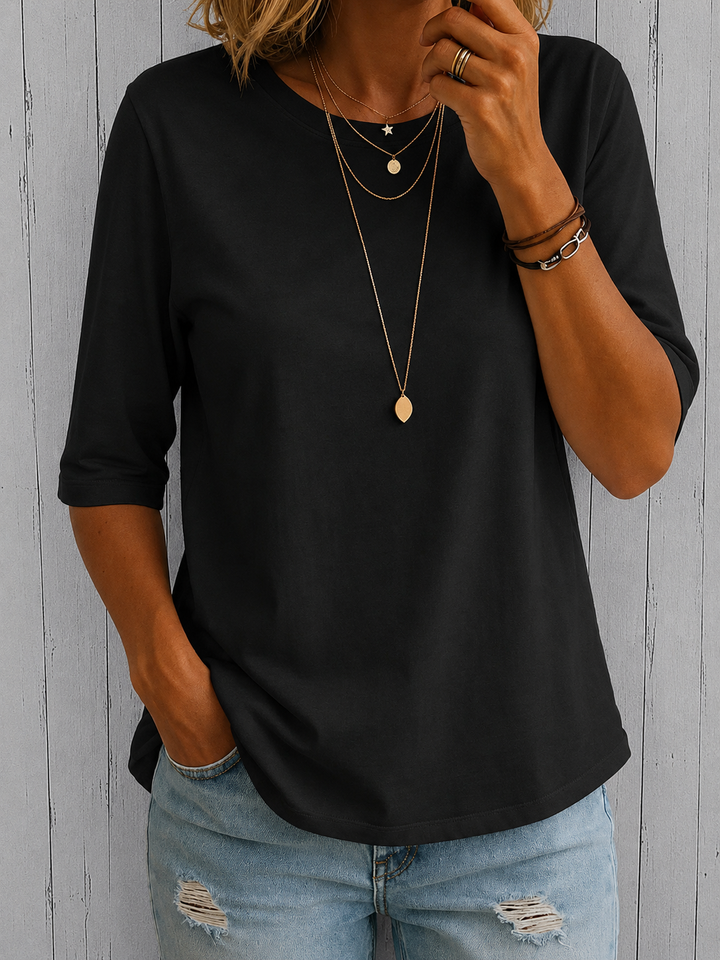 Black half-sleeve tee with a crewneck and layered gold necklaces, another view.