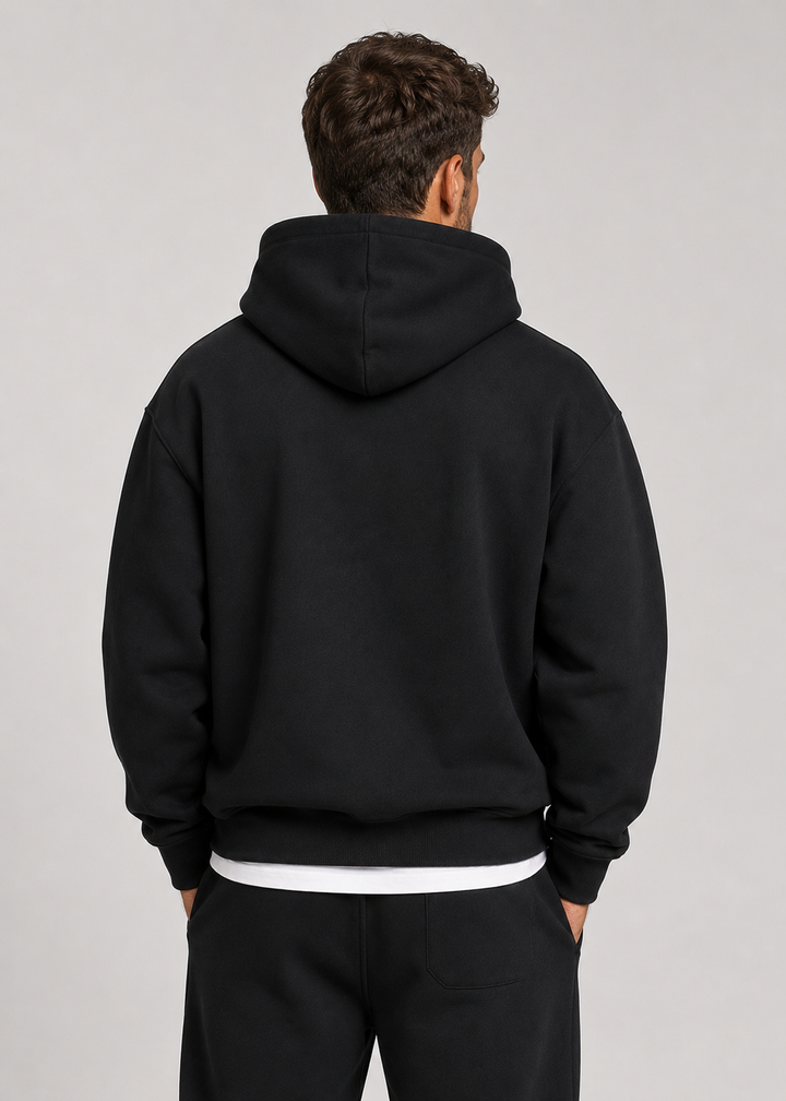 Men's black hoodie and jogger set, back view showing the patch pocket on the pants and ribbed hem.