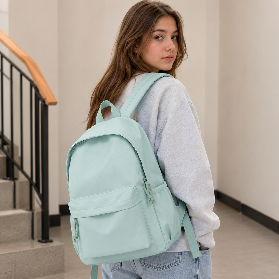 Woman wearing the mint green backpack over one shoulder.