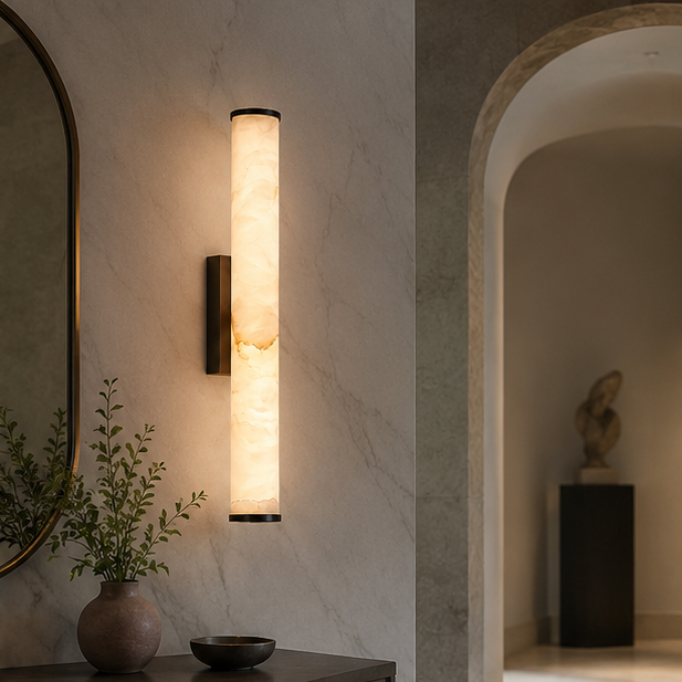 Marble sconce with dark metal fittings on a veined stone wall in a hallway with an arched doorway, vase and sculpture.