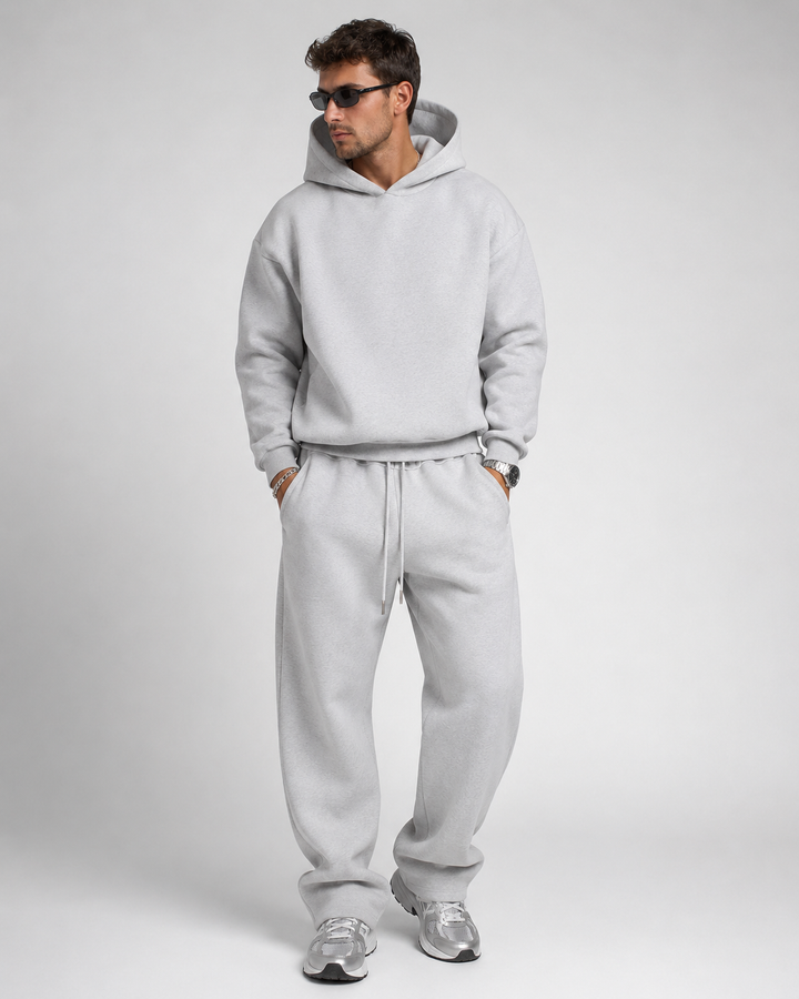 Men's light heather gray hoodie and drawstring joggers, studio view.
