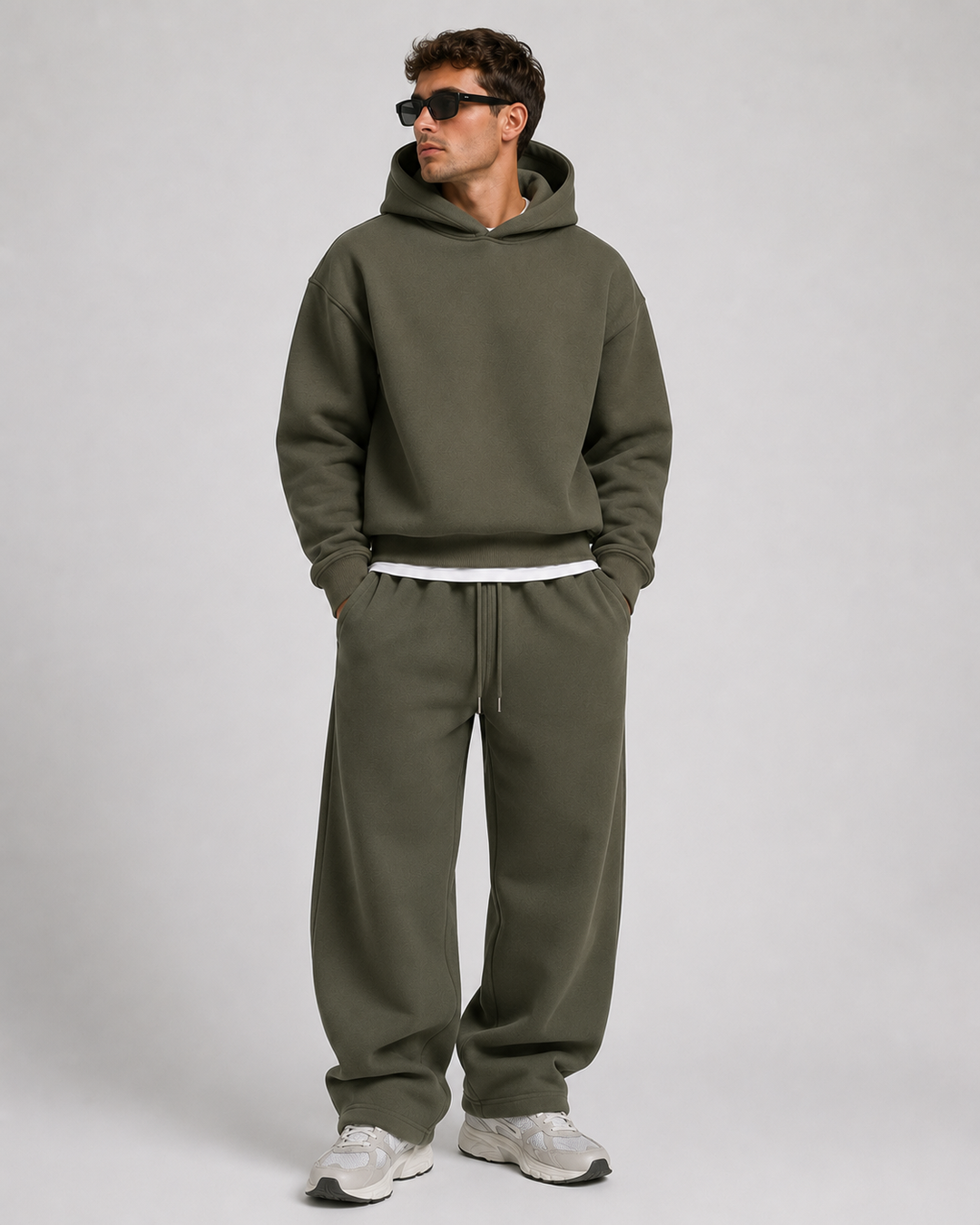 Men's olive green hoodie and wide-leg joggers, full-length studio view.
