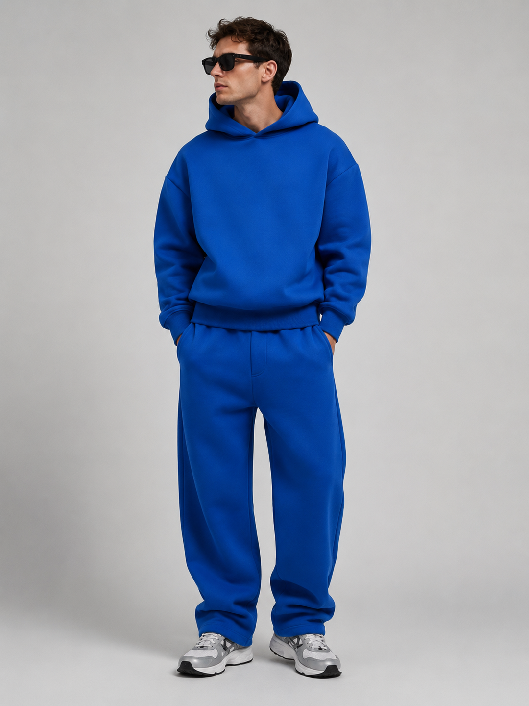 Men's cobalt blue hoodie and wide-leg joggers, full-length studio view.