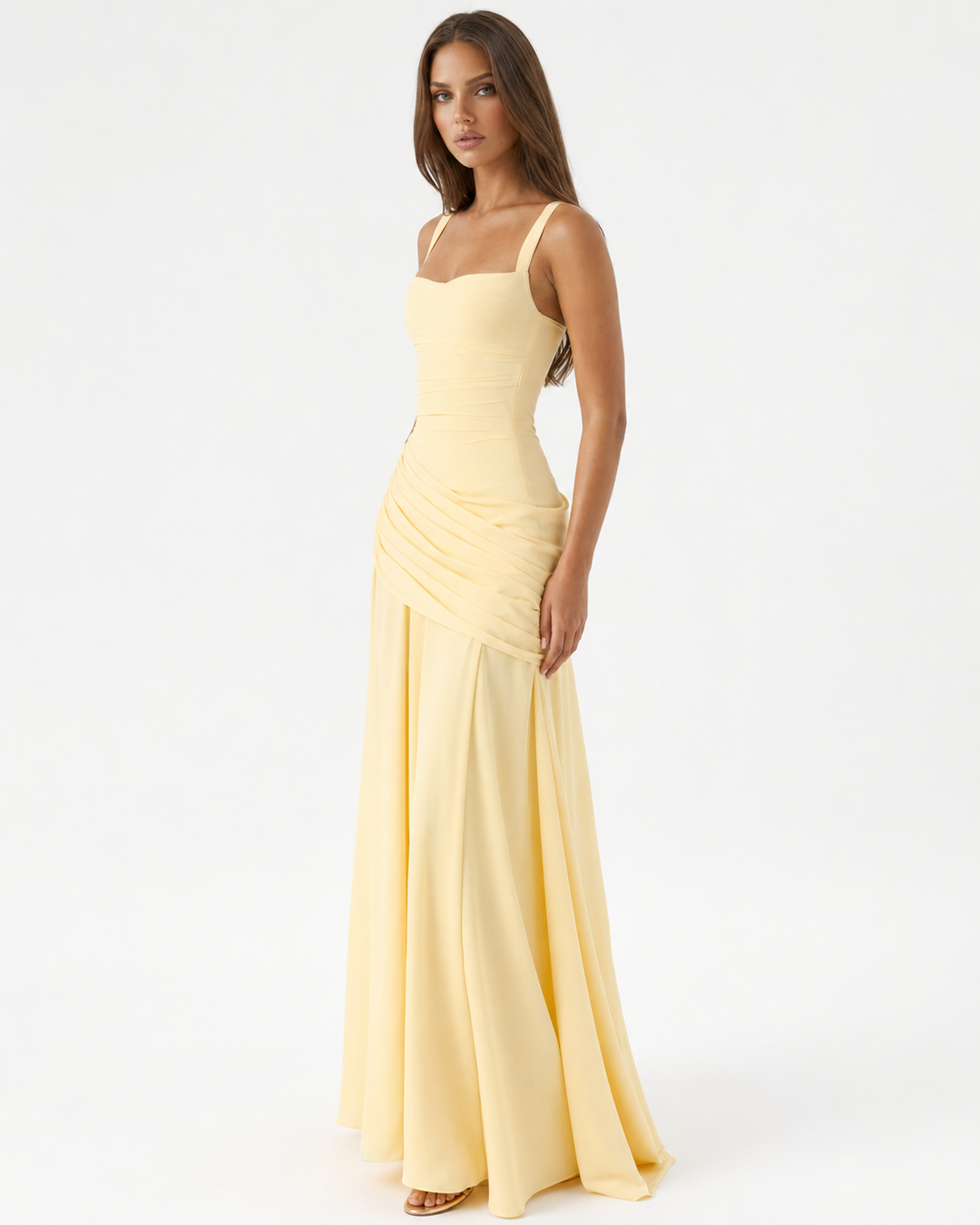 Pale yellow maxi dress seen at a three-quarter angle on a model, showing the square neckline and draped side. 2