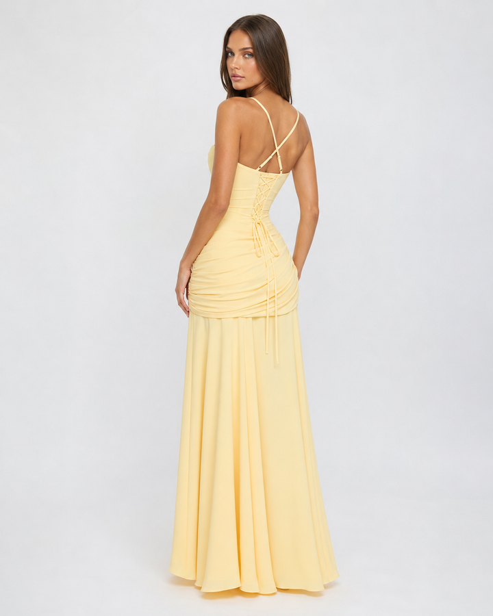 Back view of the pale yellow dress with crisscross thin straps, corset-style lace-up back and gathered hip drape. 5