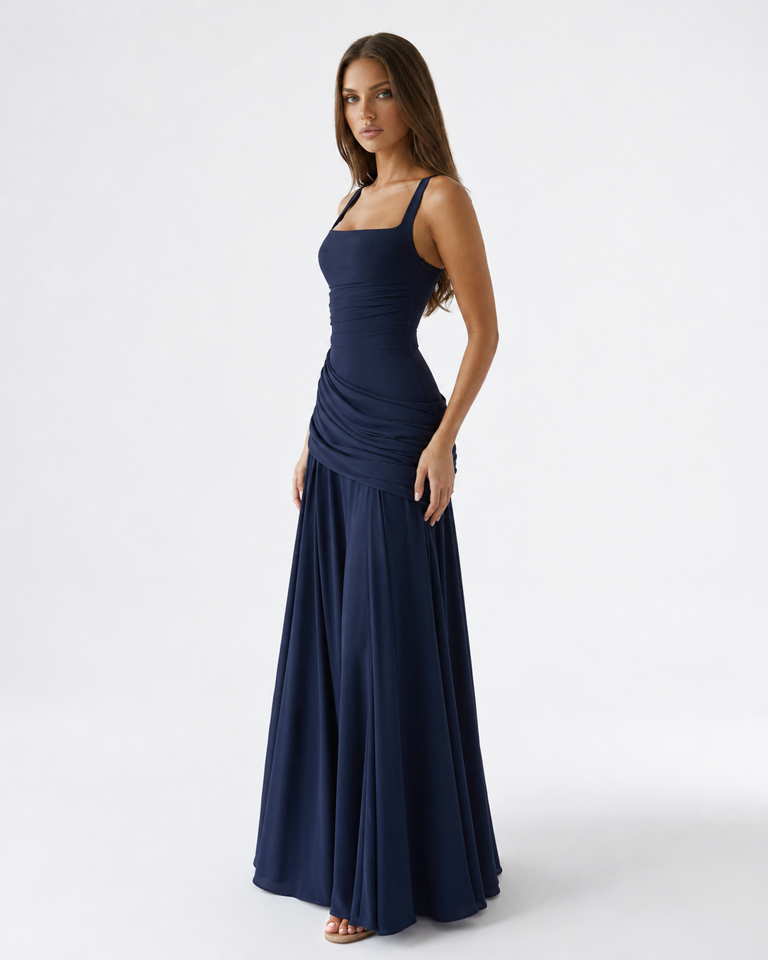 Three-quarter view of a navy blue maxi dress with square neckline and gathered waist