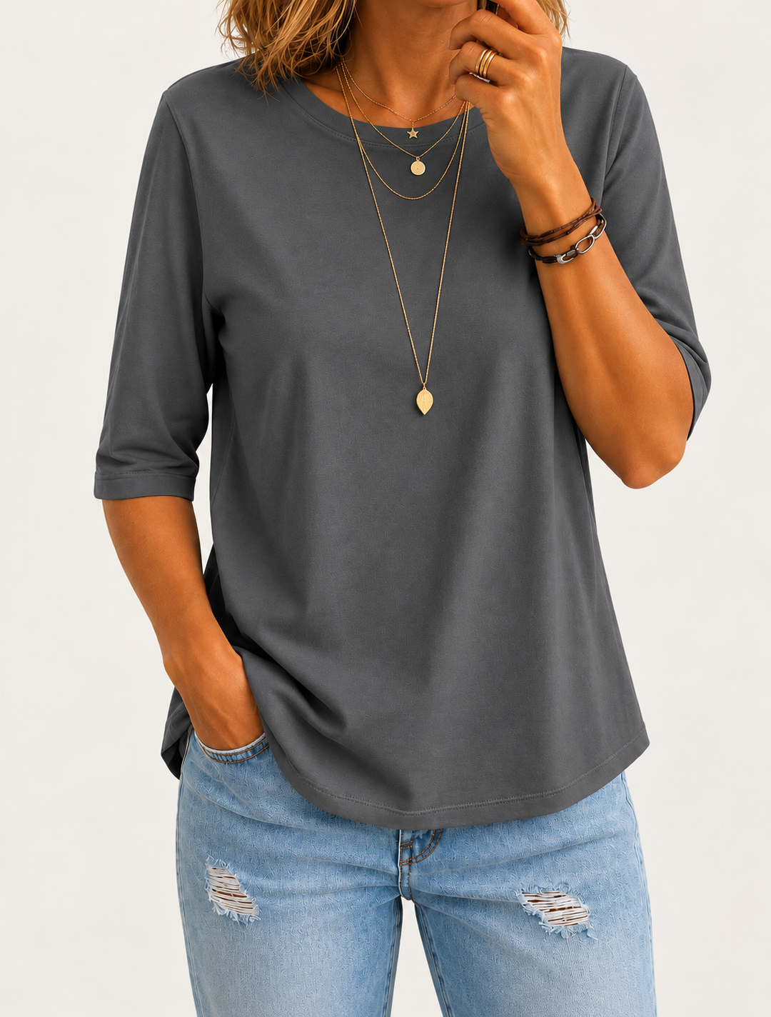 Dark gray half-sleeve tee with a crewneck and layered gold necklaces.