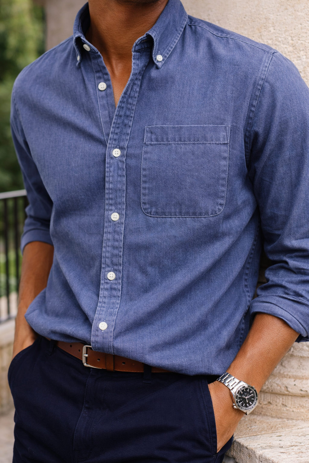 Men's cotton button-down shirt in blue with a chest pocket and white buttons, detail.