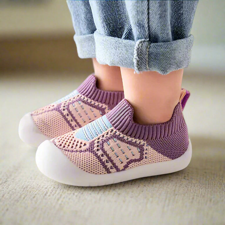 Purple and pink knit slip-on shoes with blue stripes and white soles, another view.