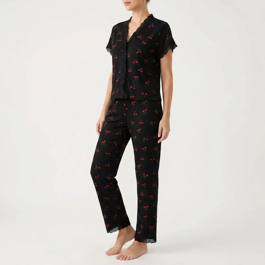 Three-quarter side view of the black cherry-print pajama set, showing the lace-trimmed V-neck, button front and straight-leg pants. 4