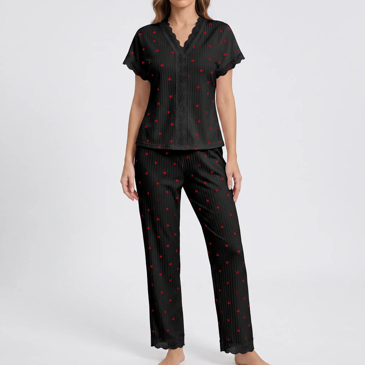 Model wearing the black ribbed pajama set with small red hearts and black lace trim on the V-neck, sleeves and pant hems. 9